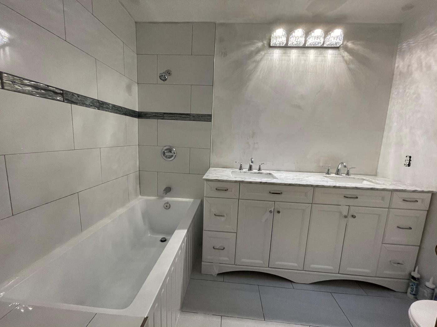 White bathroom with tub and double vanity