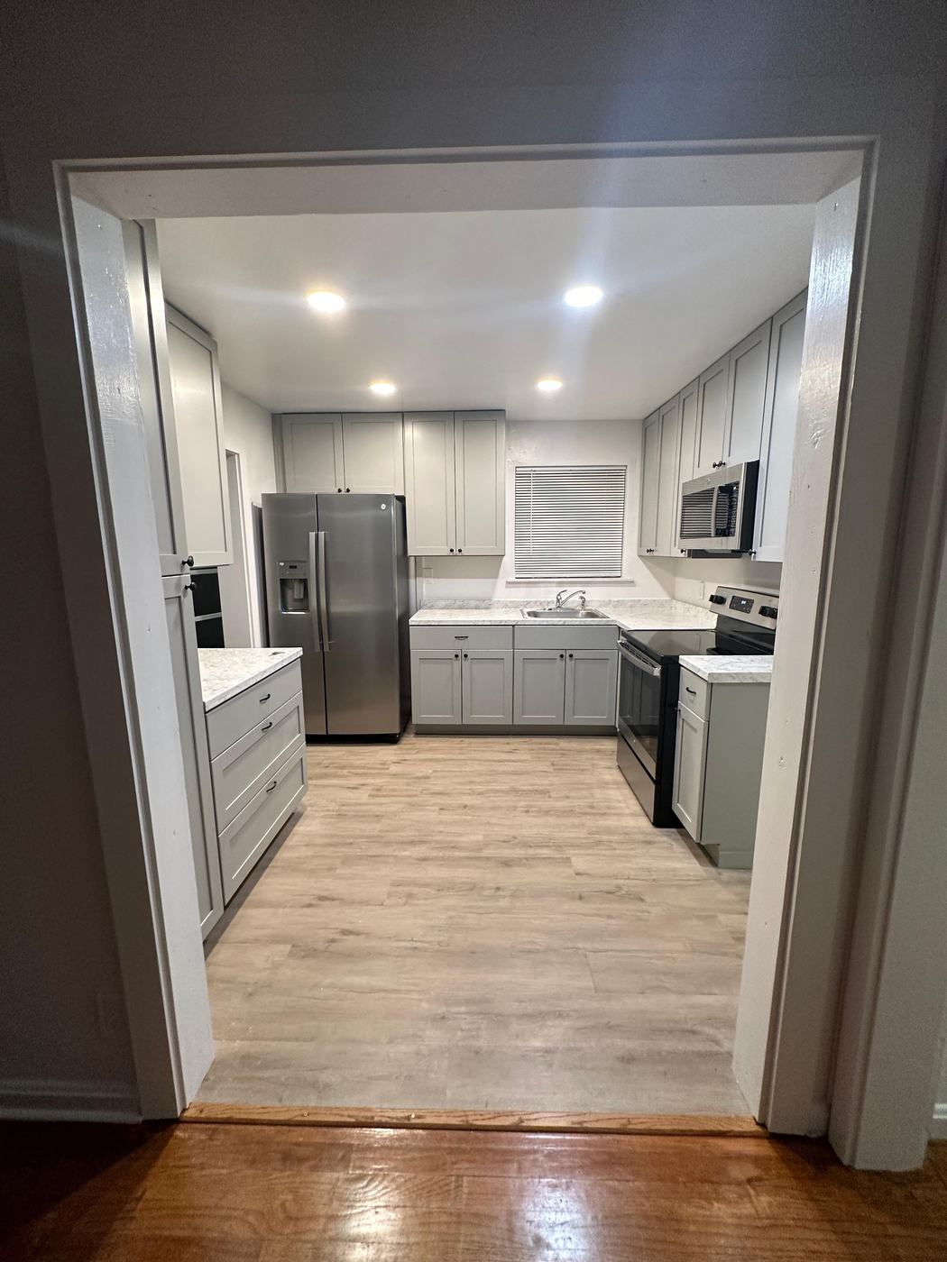 Remodeled kitchen with gray shaker cabinets and stainless appliances
